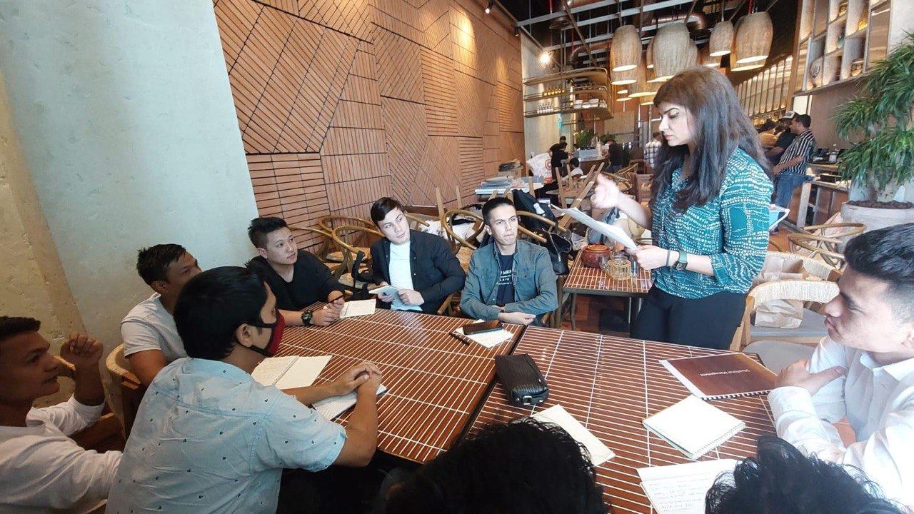 Sonia Arif leading a workshop with participants seated nearby