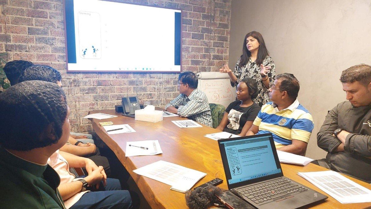 Sonia Arif facilitating a boardroom training session around a conference table