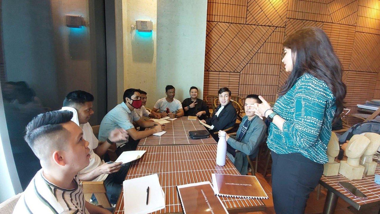 Sonia Arif coaching a team while seated together at the table